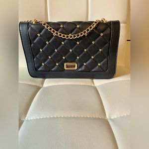 Badgley & Mischka’s black quilted crossbody bag with gold hardware